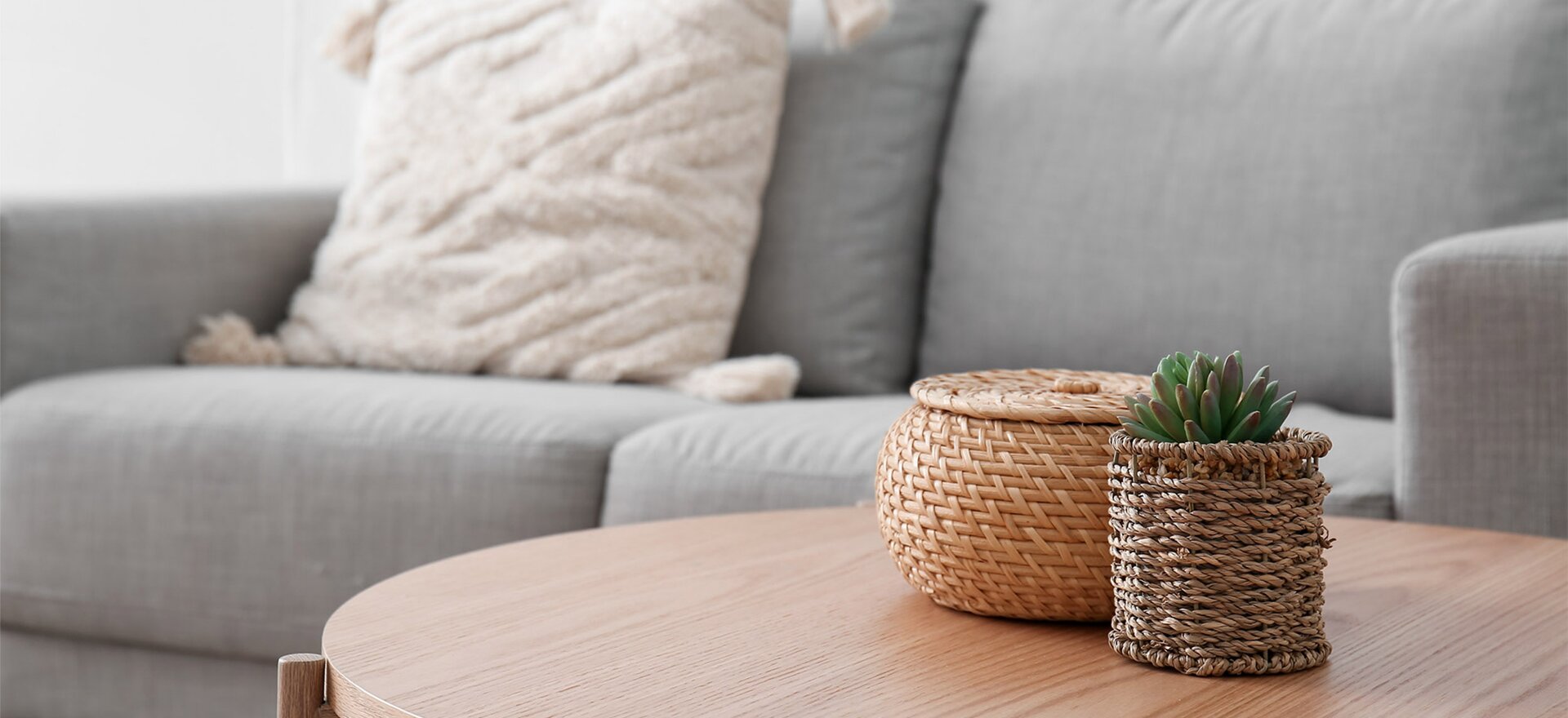 Close-up of a plush grey couch and a sleek wooden coffee table, highlighting the refined interior design of a Kinward at Spencer Glen townhome.